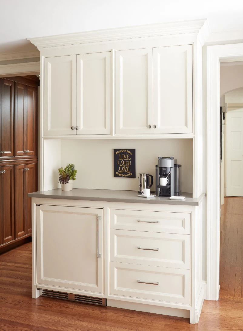 Built-in coffee station with cabinetry and undercounter refrigerator